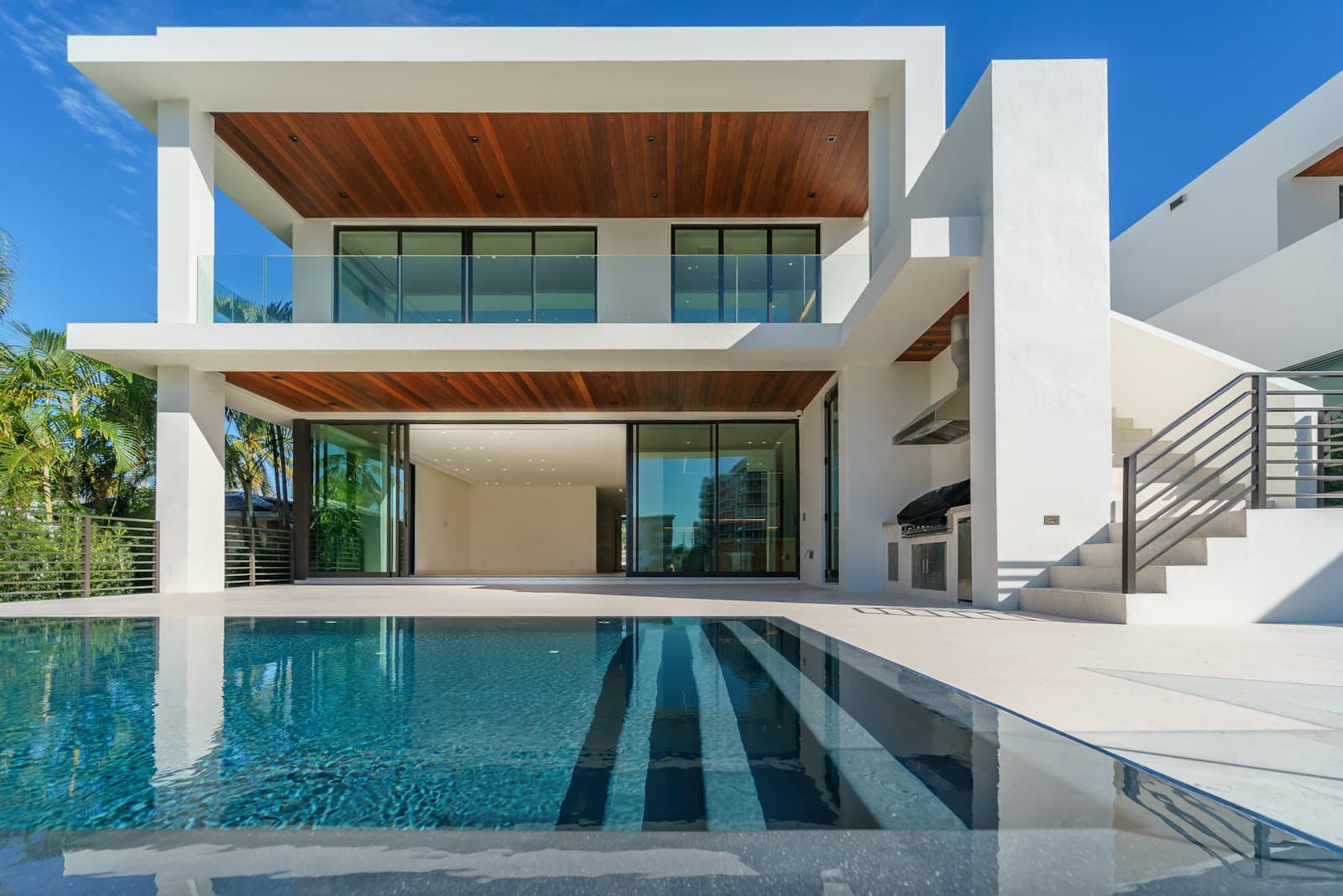 A modern coastal villa opening onto a pool and warm evening light